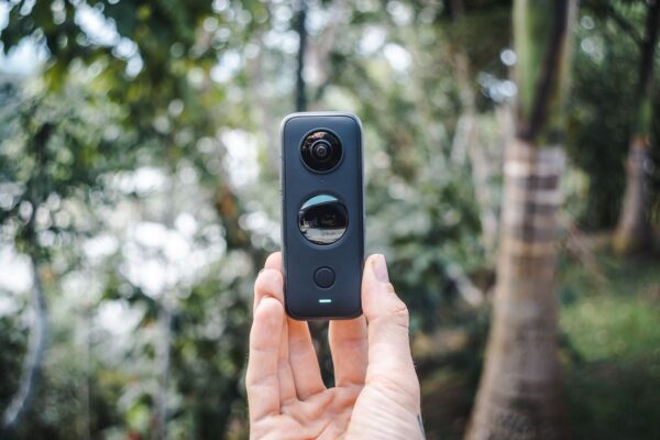 Hand holding a 360 camera outdoors
