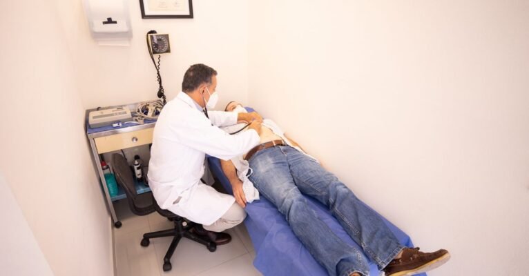 Medical professional examines patient with stethoscope in clinic examination room