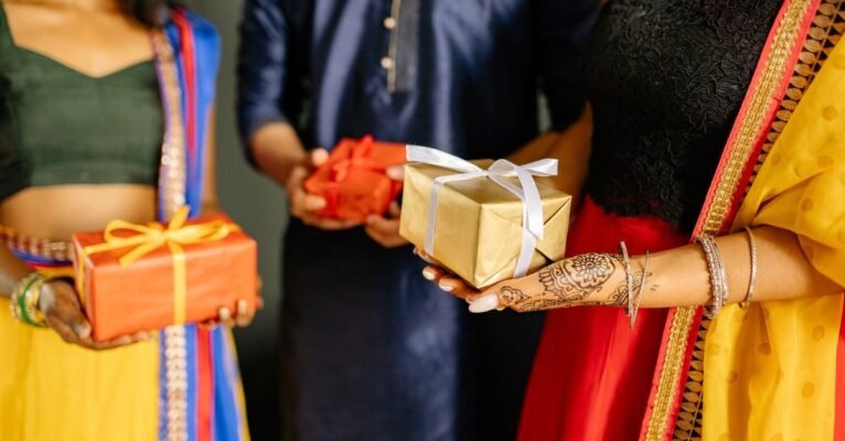 Colleagues exchanging wrapped Diwali gifts at a festive office celebration