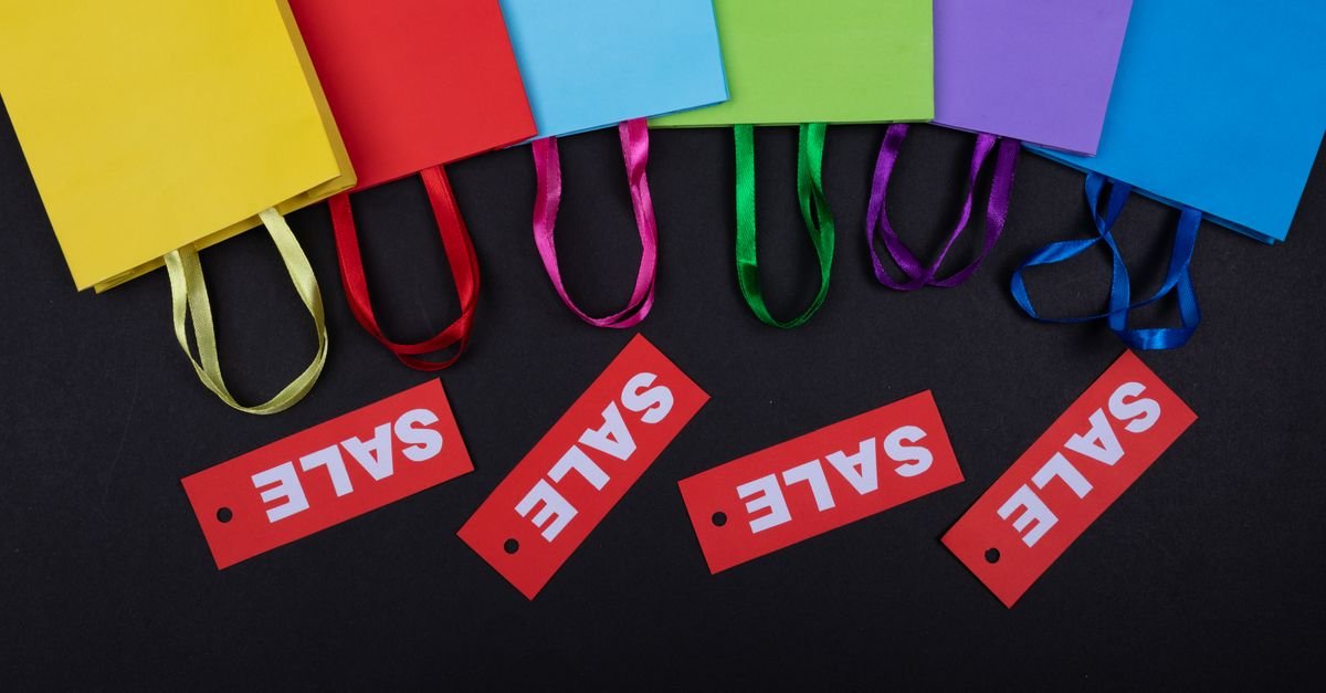 Vibrant shopping bags with sale tags on a black surface. Perfect for retail promotions